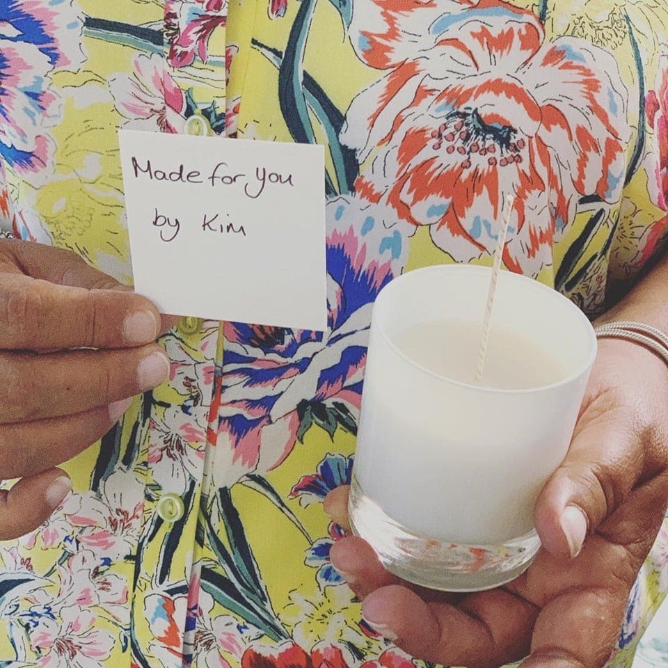 A woman holds a candle with a note that says Made for you