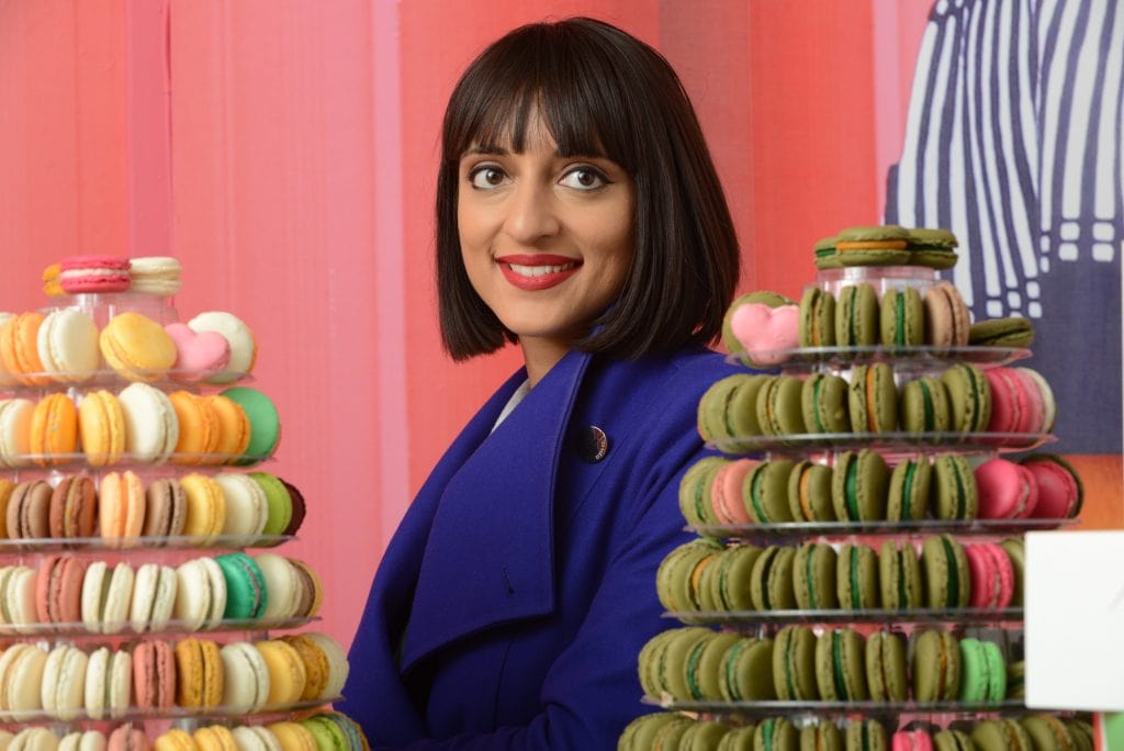 Rosie, founder of Miss Macaroon with displays of macaroons stacked around her