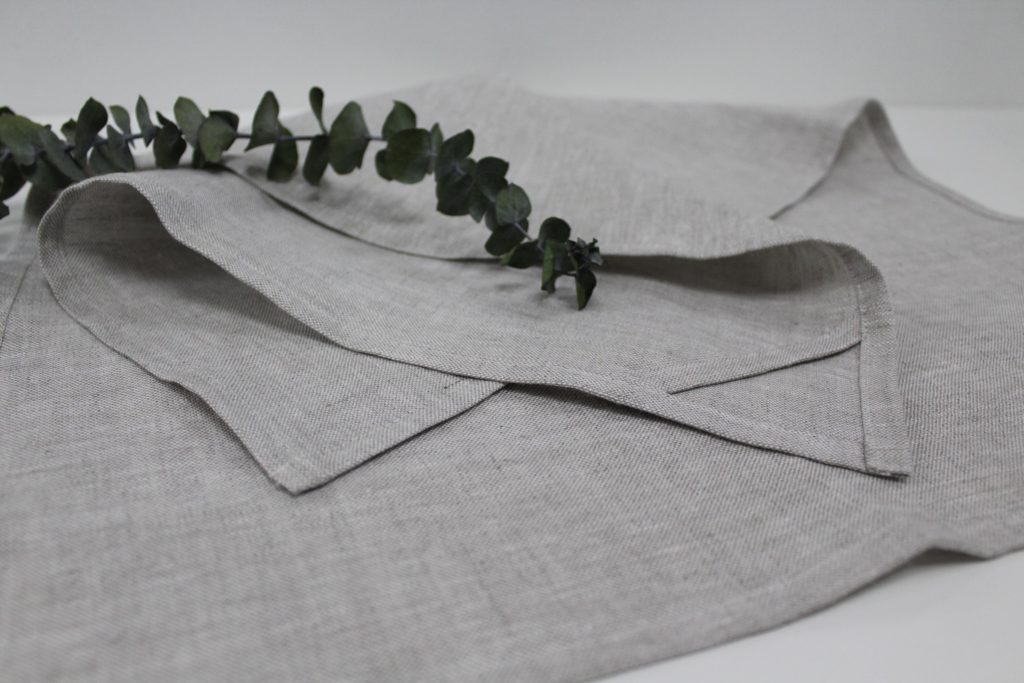 A grey tea towel with eucalyptus leaf on it