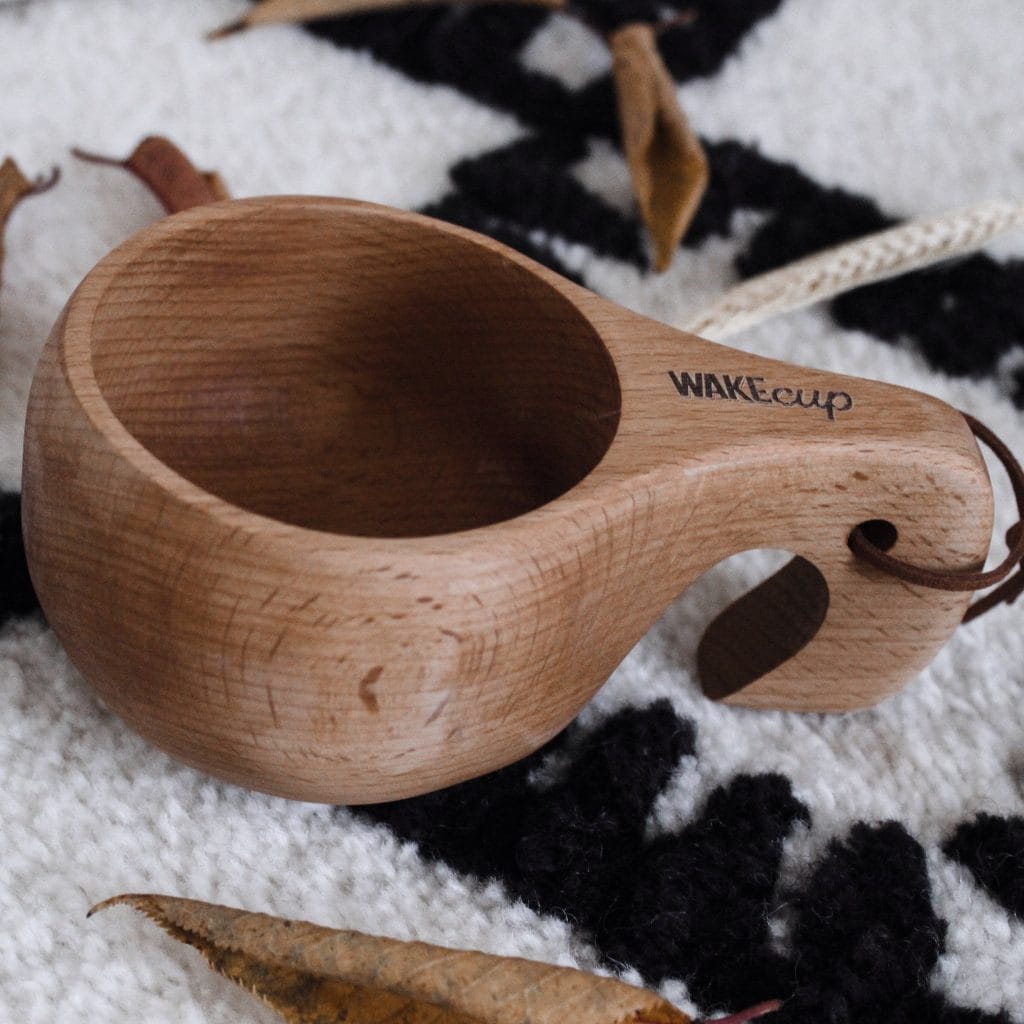 A wooden WAKEcup on a patterned blanket