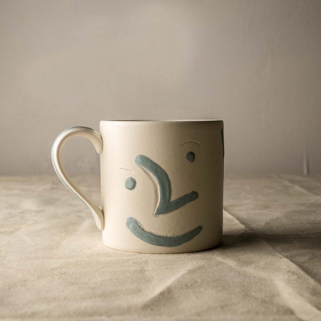 A mug with a handprinted smiling face