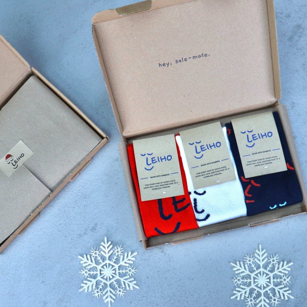A box of three Leiho socks surrounded by snowflakes