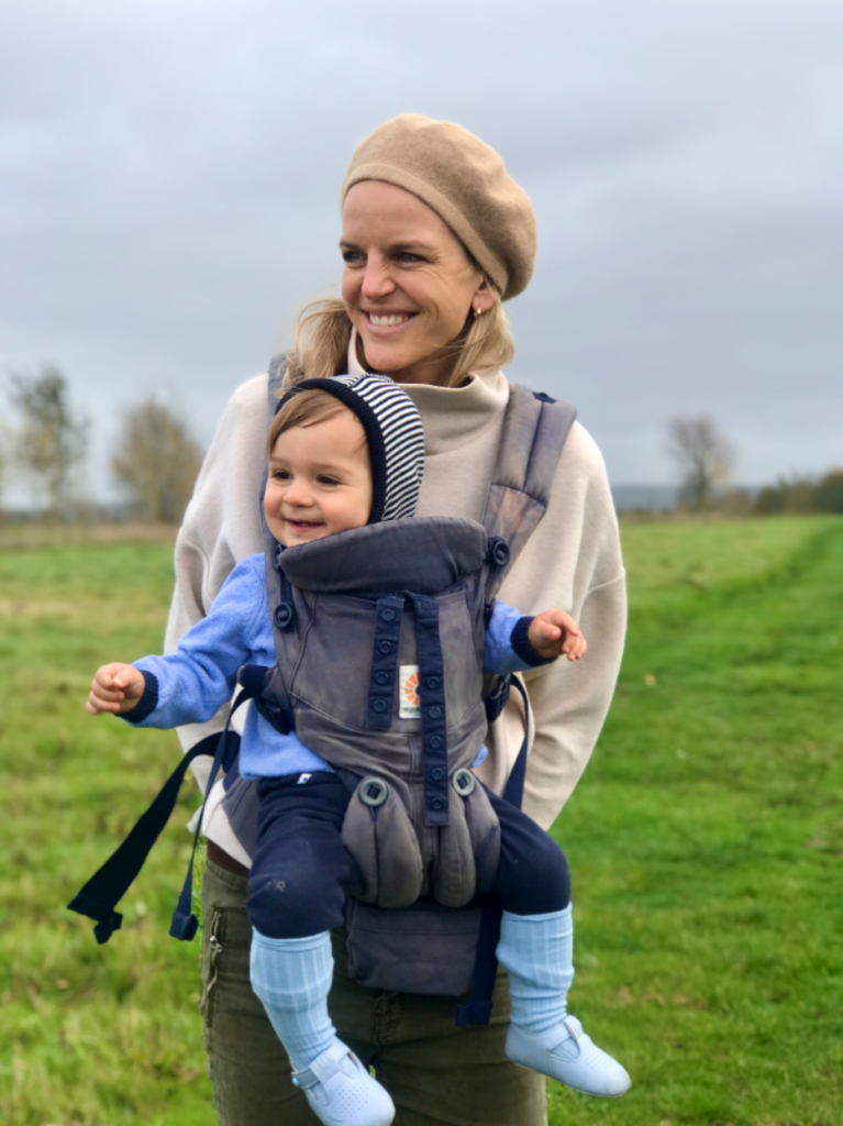 Jenny, founder of Rubies in the Rubble out for a park walk with her child in a toddler carrier