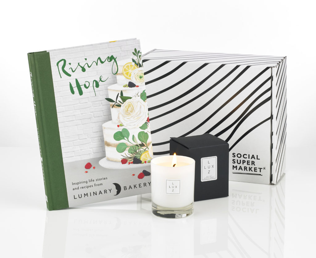 A gift box with a cookbook and candle