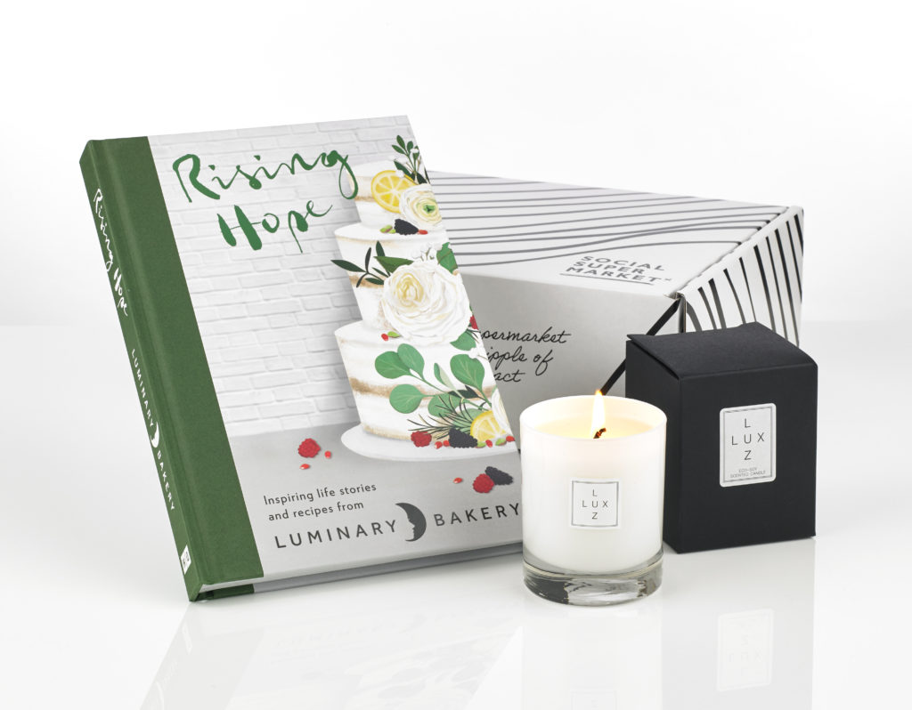 A gift box showing a cookbook and candle