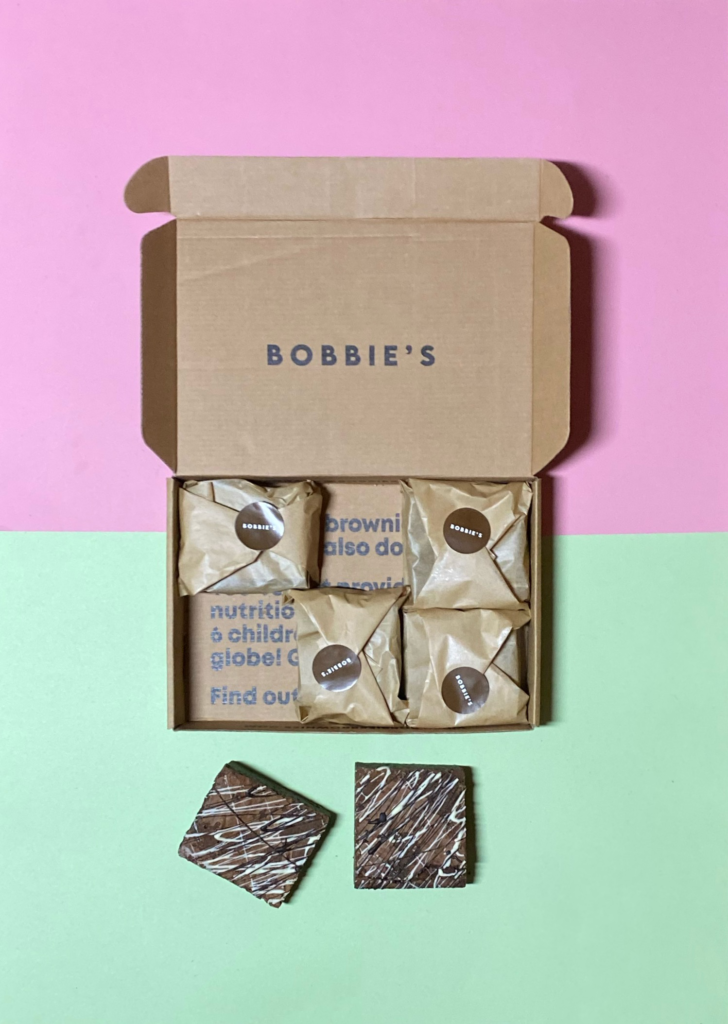 A classic 6-pack from Bobbies Brownies on a pink and green background