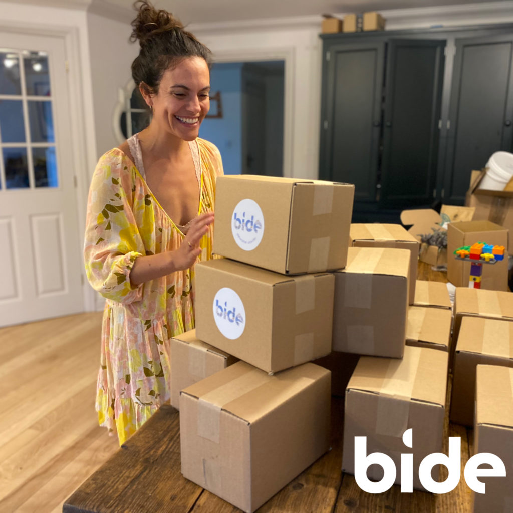 Founder of bide, Amelia with a stack of boxes ready to ship out
