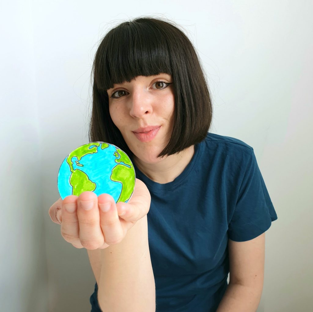 Ella Daish looks at the camera while holding a globe in her hand