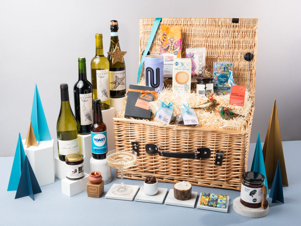 The Royal Frost Birch Christmas Hamper with its lids open and contents spilling out around it including wines rom Sea Change, beer from Toast Ale, tea from NEMI Teas, honey from Mama Buci and biscotti from Step and Stone for Social Supermarket