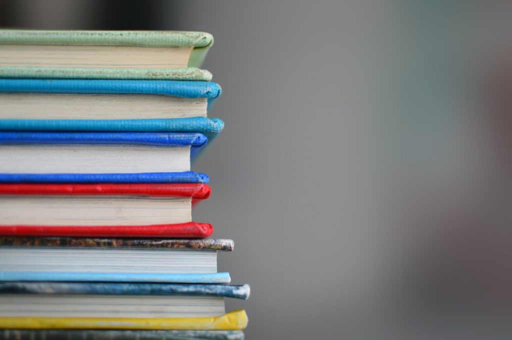 A stack of multi-coloured books on their sides.