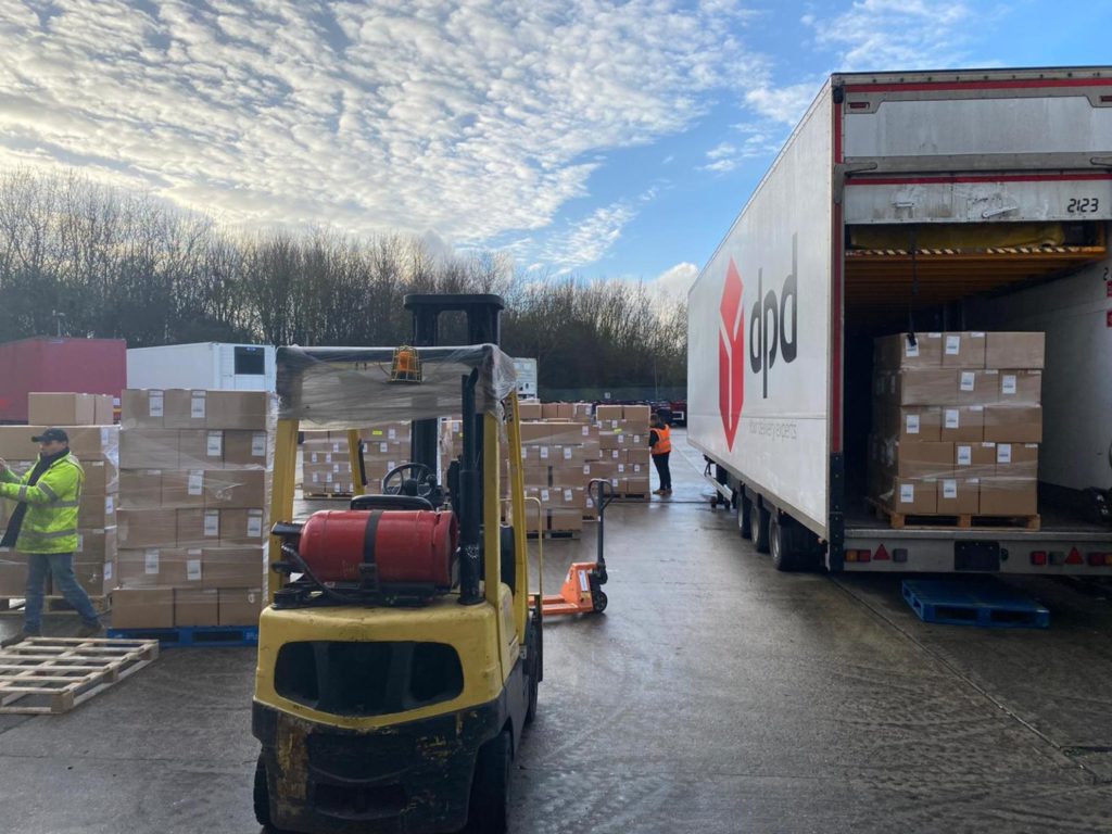 A forklift truck and double decker DPD lorry packing boxes of Christmas hampers in 2020