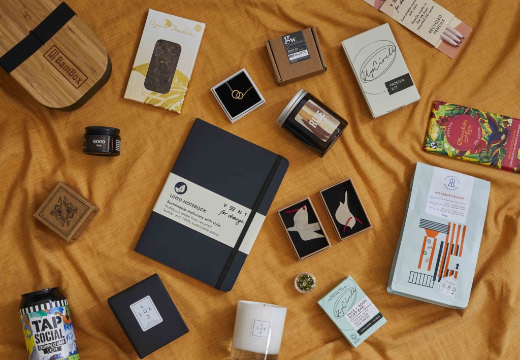 A still life overhead shot of multiple products on a gold linen tablecloth