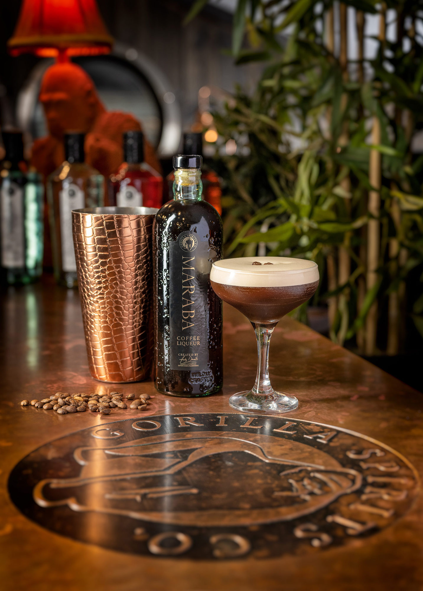 An espresso martini on a bar next to a bottle of Gorilla Spirits and a shaker.