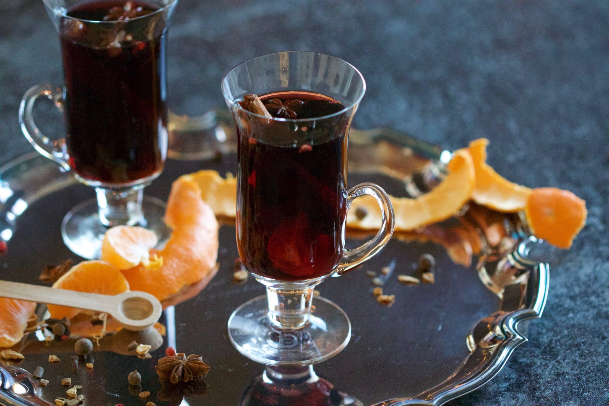 Two glasses of mulled wine on a silver tray with orange peel 