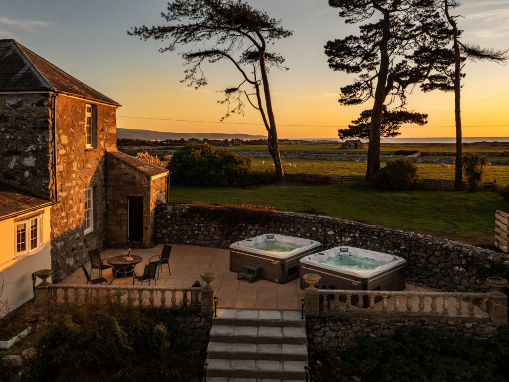 A sunset scene over a garden with hot tubs