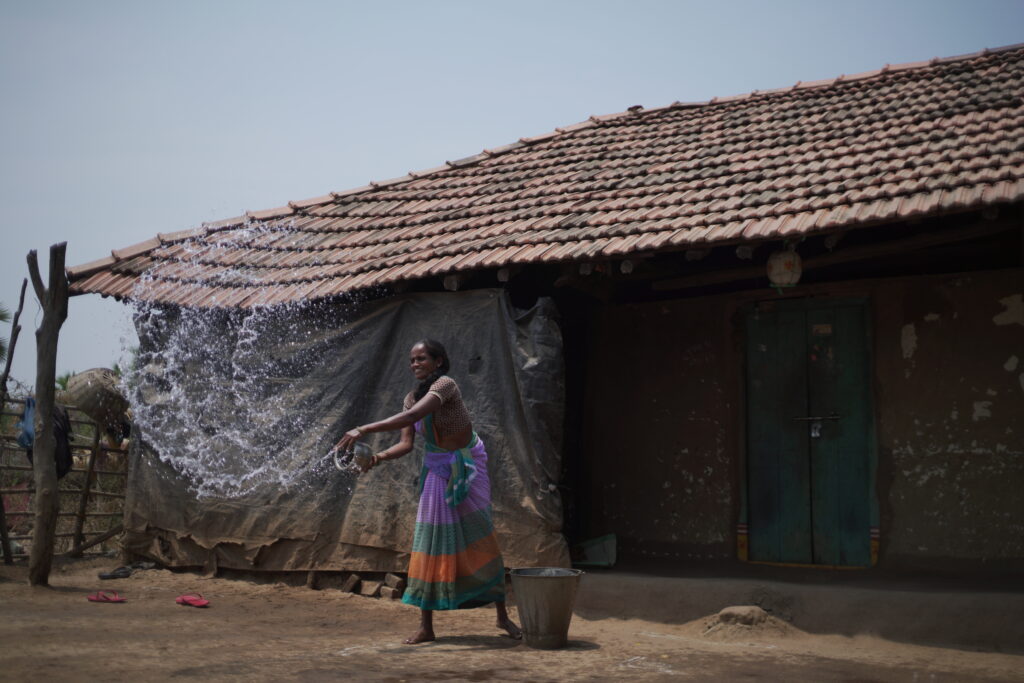 A woman cleaning the yard with water