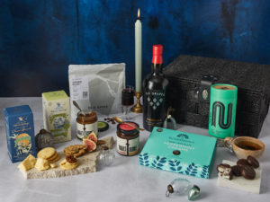 The After Dinner Hamper surrounded by the contents that are inside, including Grahams Port, NEMI Teas Peppermint Tea, Summerdown peppermint creams Rubies in the Rubble relish, Old Spike coffee and more.