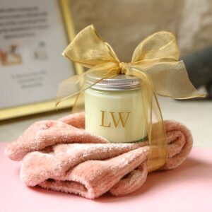 A votive candle with a pair of fluffy pink socks tied with an organza bow in gold