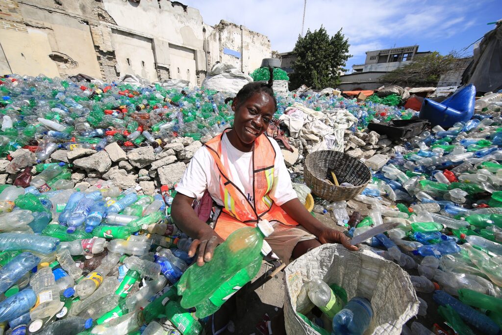 A woman collects plastic bottles