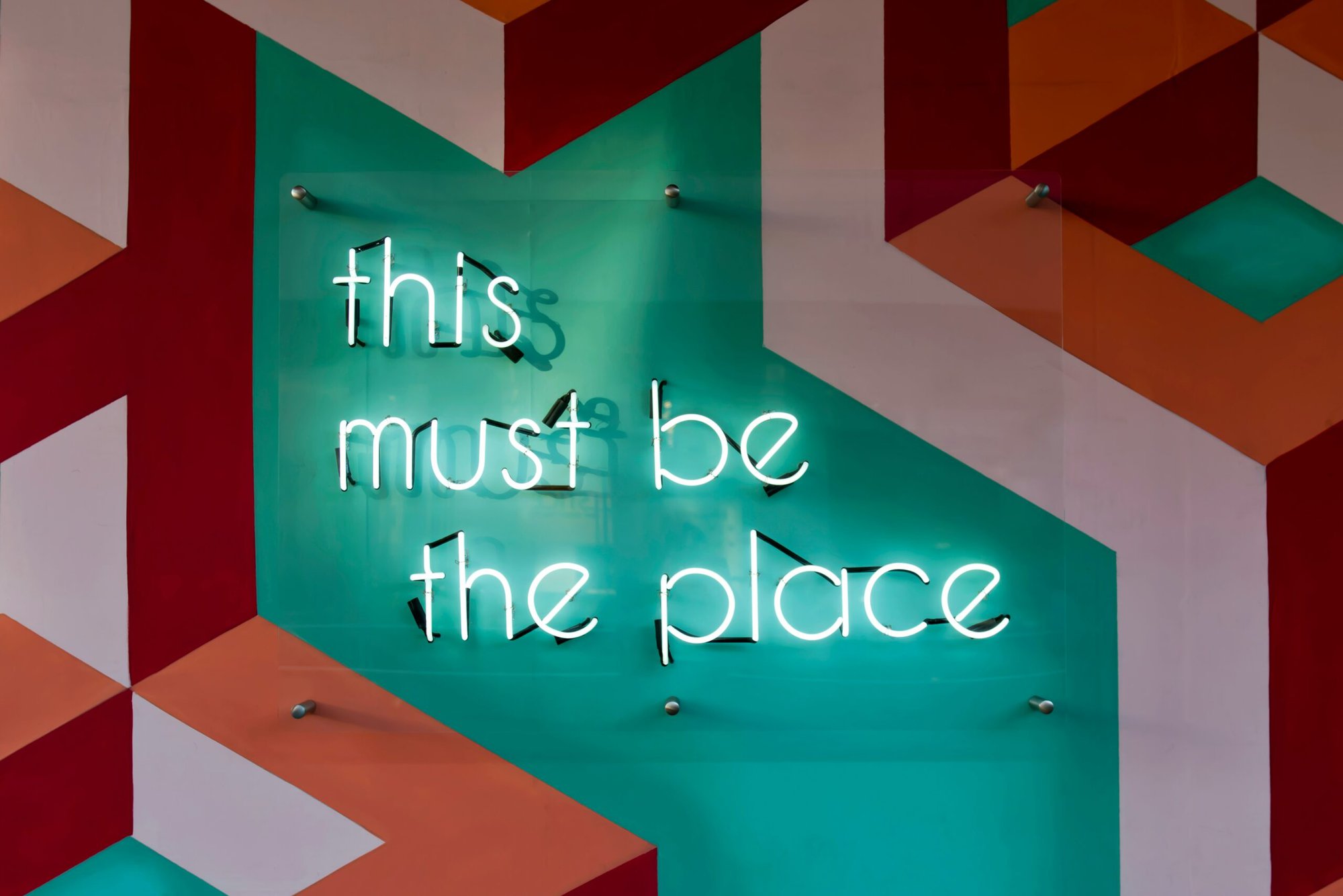 A neon sign reading "this must be the place"